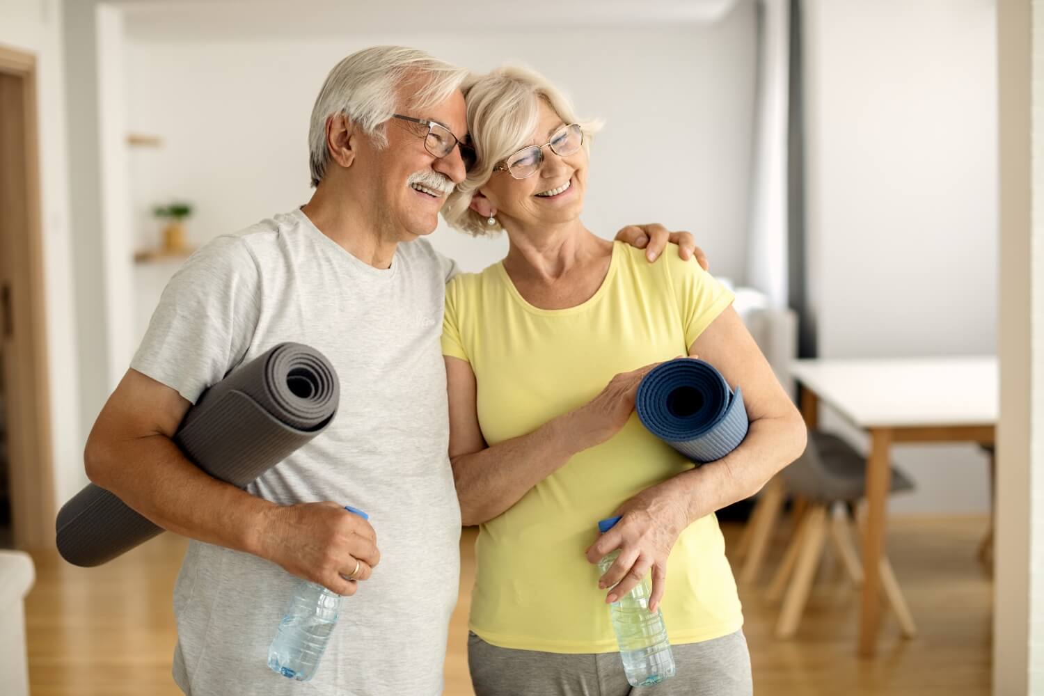 Happy mature couple embracing after working out home