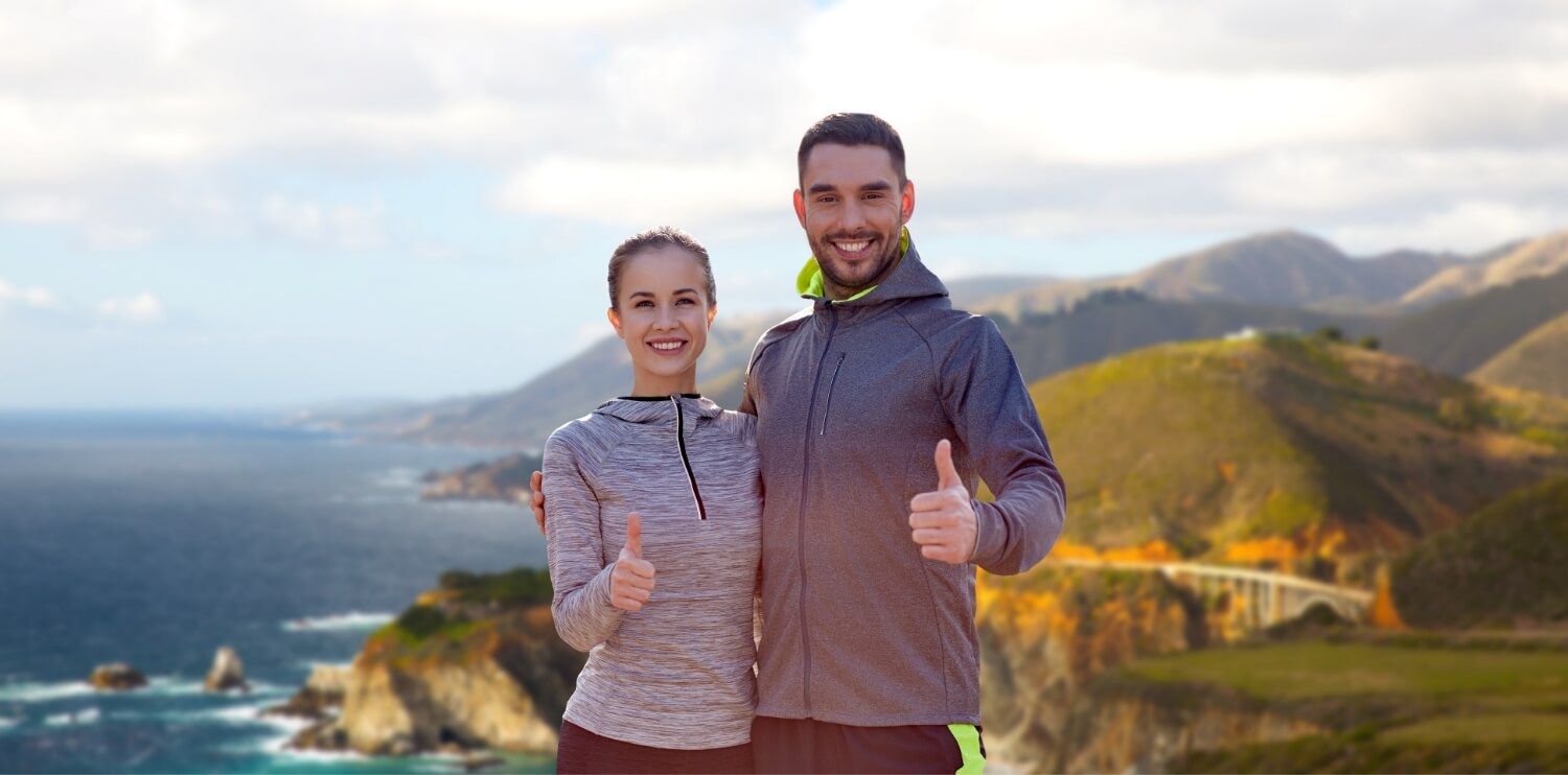 Smiling couple sport clothes showing thumbs up (1)
